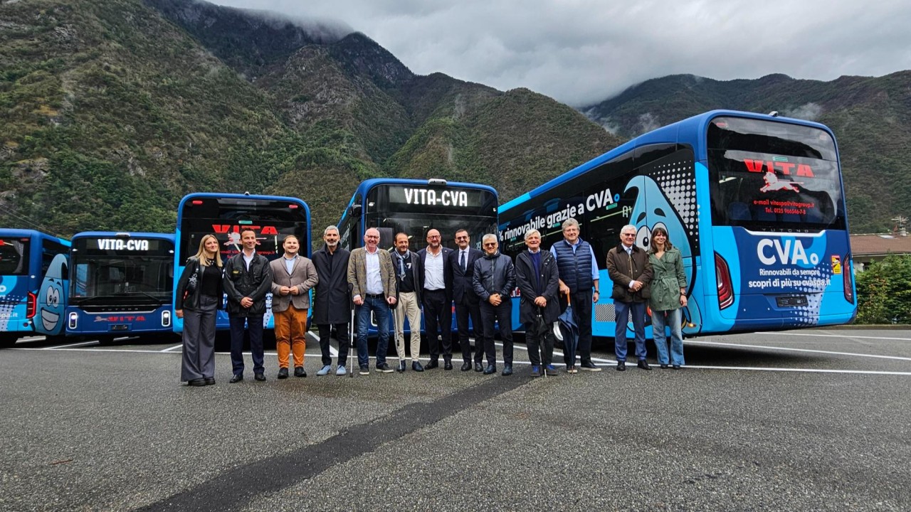 Group of CVA, V.I.T.A. and QiOn representatives at the electric bus fleet launch in Valle d'Aosta, standing in front of VITA-CVA branded Yutong electric buses powered by renewable energy