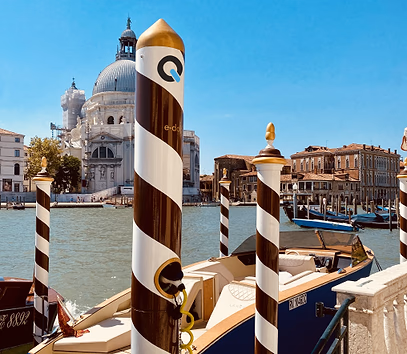 QiOn E-Dock integrated into traditional Venetian striped mooring poles on the Grand Canal with a gondola and Santa Maria della Salute basilica in the background, showing design harmony with heritage waterfront