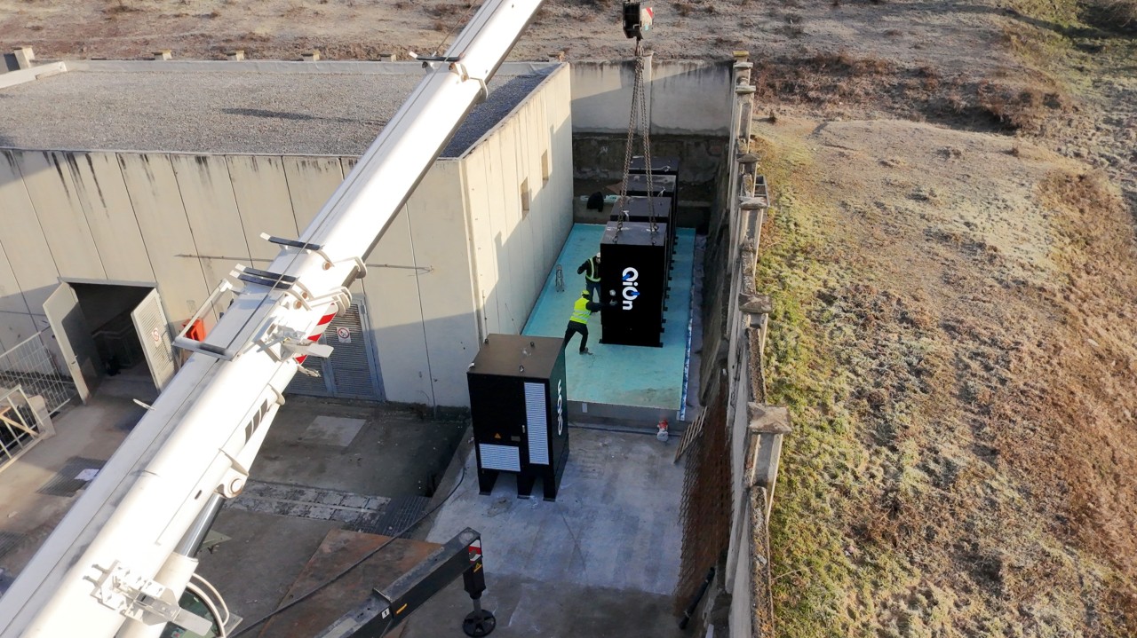 Aerial view of QiOn ThunderCell 250 kWh BESS units being crane-installed at an industrial facility in Chatillon, Italy, for grid ancillary services and industrial energy flexibility